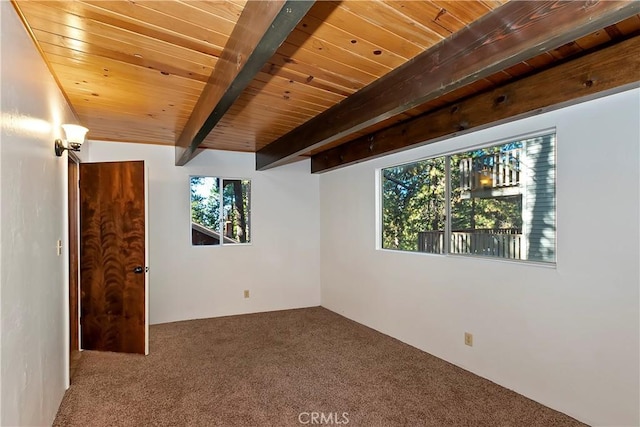 unfurnished room featuring carpet flooring, beam ceiling, and wooden ceiling