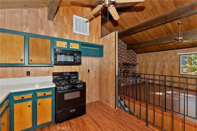 kitchen featuring ceiling fan, lofted ceiling with beams, wood walls, black appliances, and light wood-type flooring