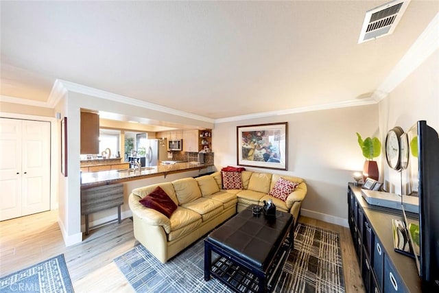 living room featuring crown molding and light hardwood / wood-style floors