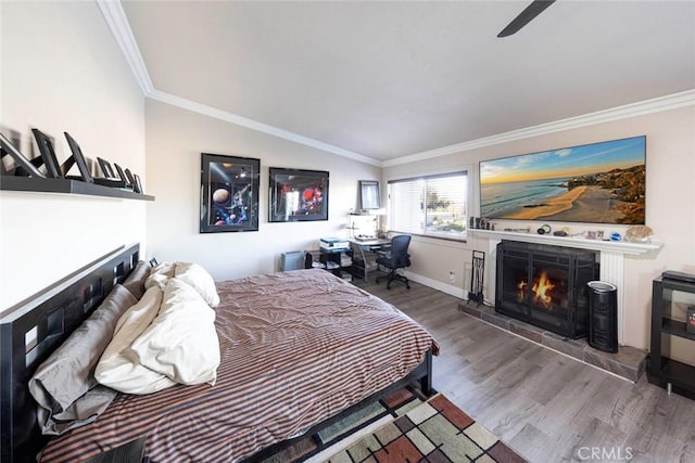 bedroom with hardwood / wood-style flooring, ceiling fan, crown molding, and vaulted ceiling