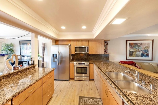 kitchen with stone counters, sink, light hardwood / wood-style flooring, backsplash, and appliances with stainless steel finishes