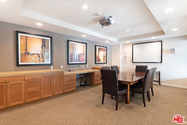 carpeted dining area featuring a raised ceiling