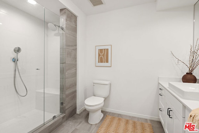 bathroom with hardwood / wood-style floors, vanity, a shower with shower door, and toilet