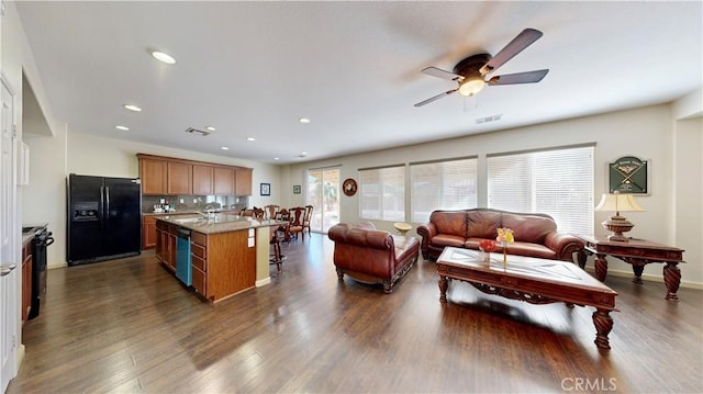 kitchen featuring ceiling fan, a center island, sink, dark hardwood / wood-style flooring, and black appliances