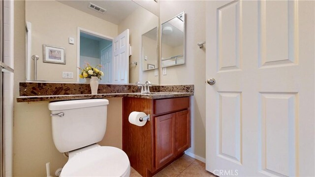 bathroom featuring tile patterned floors, vanity, and toilet