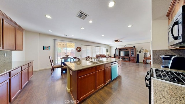 kitchen featuring ceiling fan, light stone countertops, dark wood-type flooring, stainless steel appliances, and backsplash