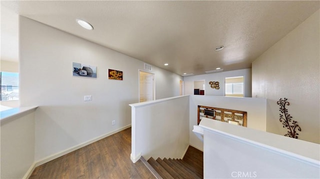 corridor with dark hardwood / wood-style flooring and a wealth of natural light