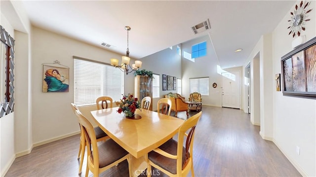 dining area featuring wood-type flooring and an inviting chandelier