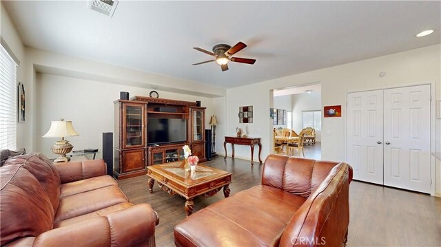 living room featuring dark hardwood / wood-style floors and ceiling fan