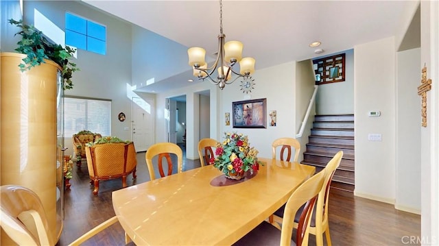 dining area with dark hardwood / wood-style flooring and an inviting chandelier