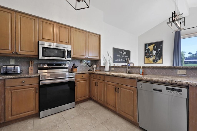 kitchen with lofted ceiling, sink, appliances with stainless steel finishes, and tasteful backsplash