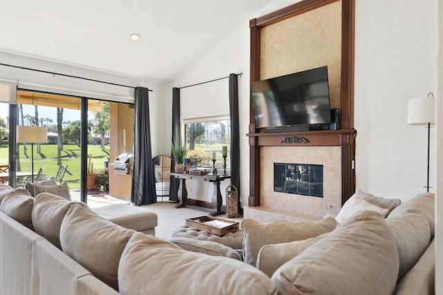 carpeted living room with lofted ceiling and a tiled fireplace