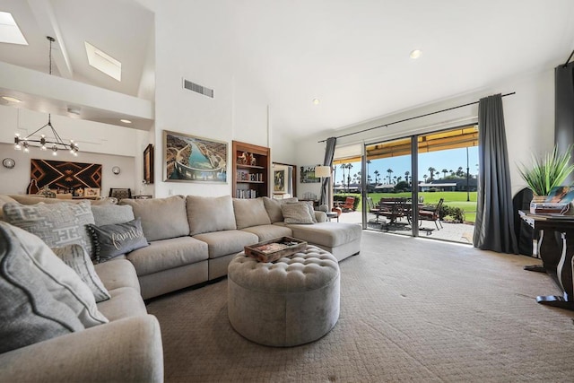 carpeted living room featuring high vaulted ceiling and a skylight