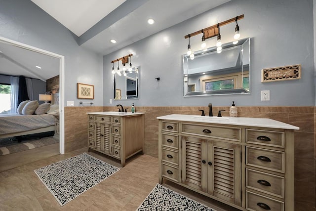 bathroom with vanity, tile patterned floors, tile walls, and lofted ceiling