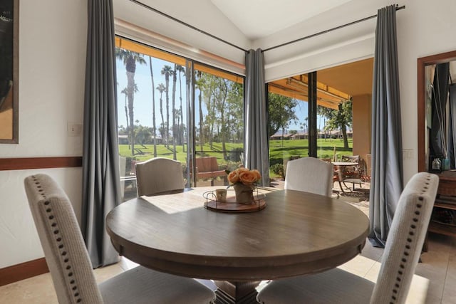 dining room featuring lofted ceiling and light tile patterned flooring