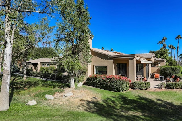 back of house featuring a yard and a patio area