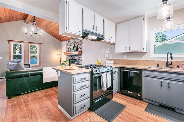 kitchen with black appliances, decorative light fixtures, white cabinetry, and a wealth of natural light