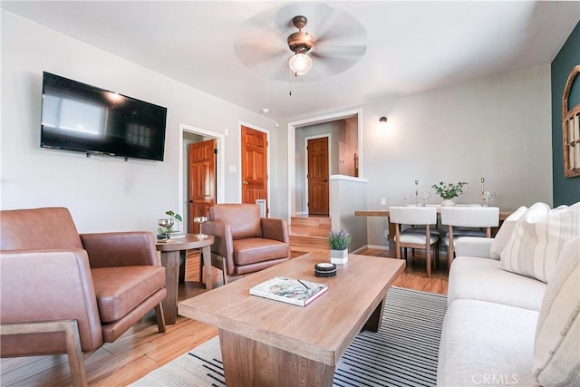 living room with ceiling fan and light hardwood / wood-style flooring