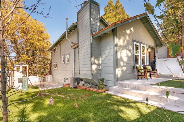 rear view of house with a yard and central AC unit