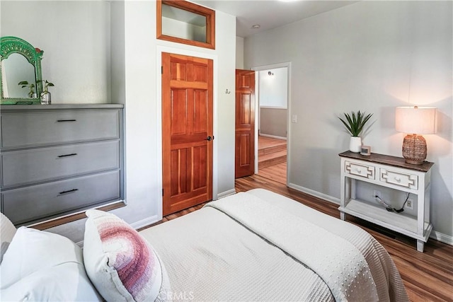 bedroom with dark hardwood / wood-style flooring