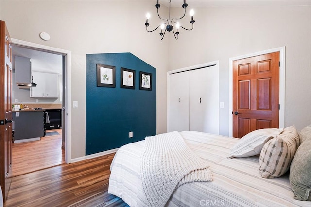 bedroom featuring a towering ceiling, dark hardwood / wood-style flooring, a closet, and a notable chandelier