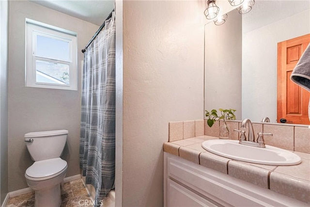 bathroom with curtained shower, vanity, and toilet