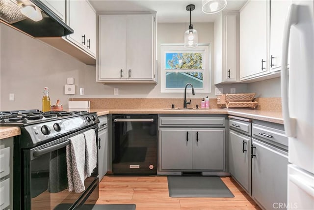 kitchen featuring black appliances, ventilation hood, sink, light wood-type flooring, and white cabinetry