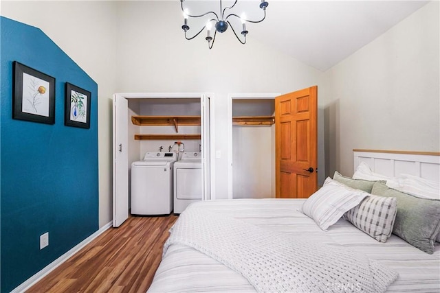 bedroom featuring hardwood / wood-style floors, a notable chandelier, lofted ceiling, and washing machine and clothes dryer