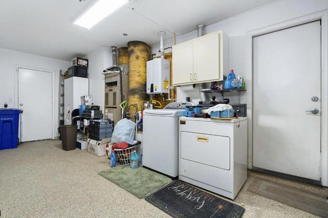 washroom featuring tankless water heater, cabinets, and separate washer and dryer