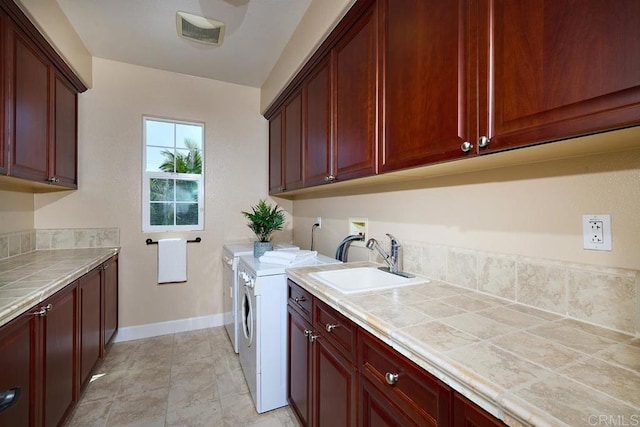 laundry area with washer and clothes dryer, visible vents, cabinet space, a sink, and baseboards