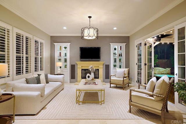 living area featuring recessed lighting, ornamental molding, a notable chandelier, and a glass covered fireplace