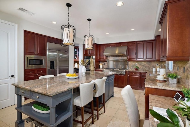 kitchen featuring built in appliances, a sink, visible vents, range hood, and decorative backsplash