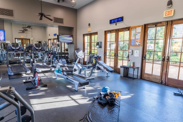 gym featuring ceiling fan, french doors, a towering ceiling, and visible vents