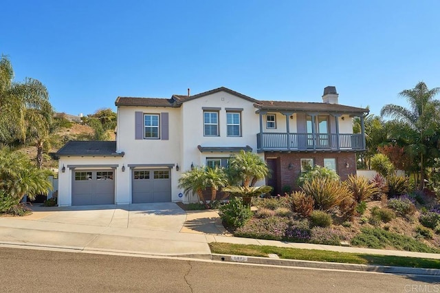 view of front facade with a chimney, stucco siding, concrete driveway, an attached garage, and a balcony