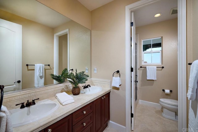 bathroom with double vanity, visible vents, toilet, and a sink