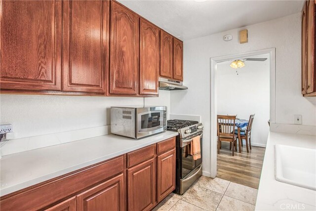 kitchen featuring ceiling fan, sink, stainless steel appliances, and light hardwood / wood-style flooring