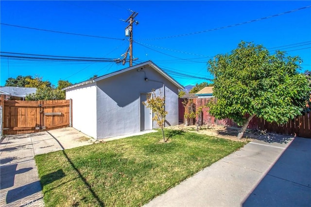 view of home's exterior featuring a lawn and an outdoor structure