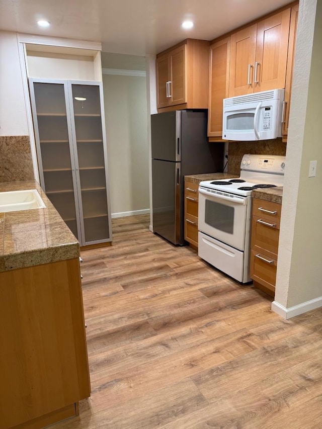 kitchen with white appliances, sink, and light wood-type flooring