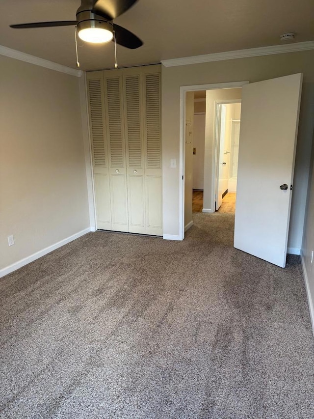 unfurnished bedroom with ornamental molding, carpet flooring, ceiling fan, and a closet