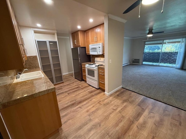 kitchen with an AC wall unit, sink, light wood-type flooring, ceiling fan, and white appliances