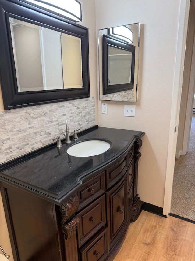 bathroom featuring decorative backsplash, vanity, and wood-type flooring