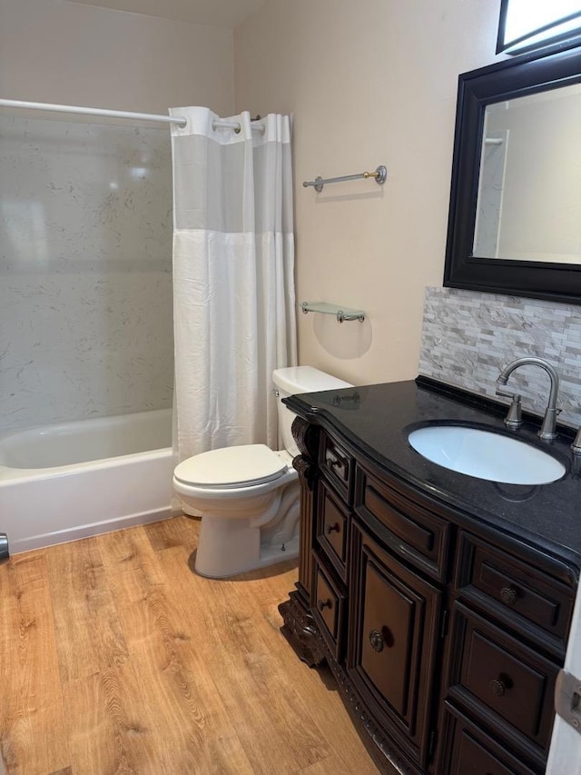 full bathroom featuring toilet, tasteful backsplash, vanity, shower / bath combo, and hardwood / wood-style floors