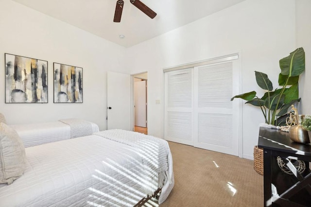 bedroom with light carpet, ceiling fan, and a closet