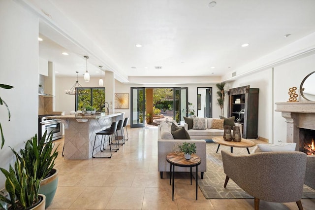 living room featuring an inviting chandelier, light tile patterned floors, a tray ceiling, and a fireplace