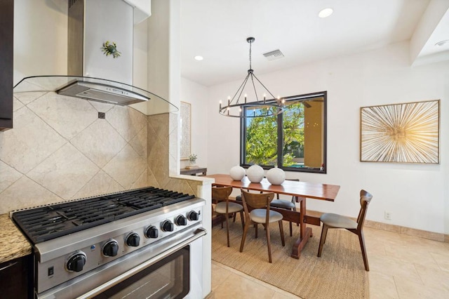 kitchen with a chandelier, decorative backsplash, high end stainless steel range oven, hanging light fixtures, and wall chimney exhaust hood