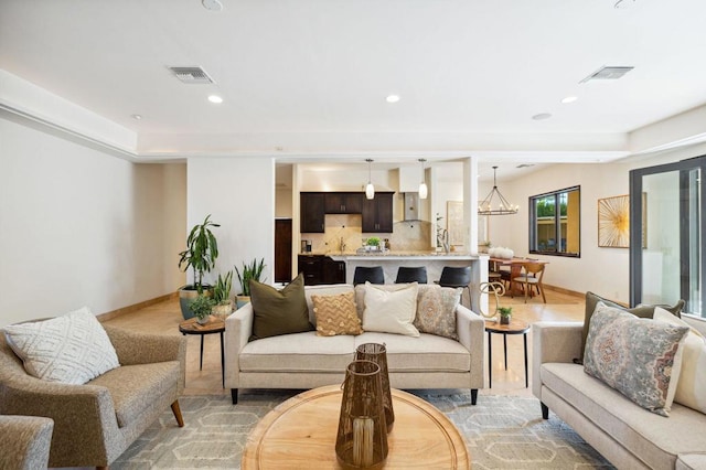 living room featuring a raised ceiling and a notable chandelier