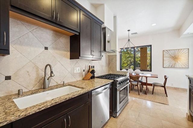 kitchen with sink, tasteful backsplash, decorative light fixtures, stainless steel appliances, and light stone countertops