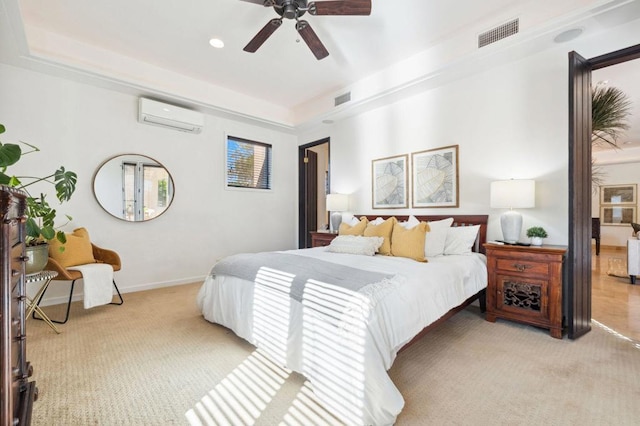 carpeted bedroom with a wall mounted air conditioner, a raised ceiling, and ceiling fan