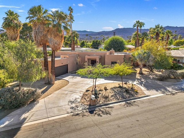 view of front of property with a garage and a mountain view