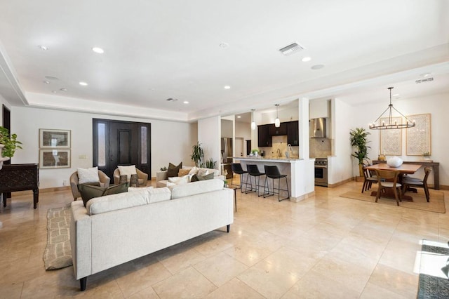 living room featuring a tray ceiling and a chandelier